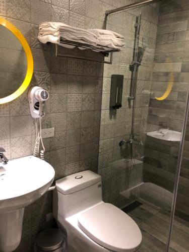 a bathroom with a toilet and a sink and a shower at Jiufen HappyLand B&B in Jiufen