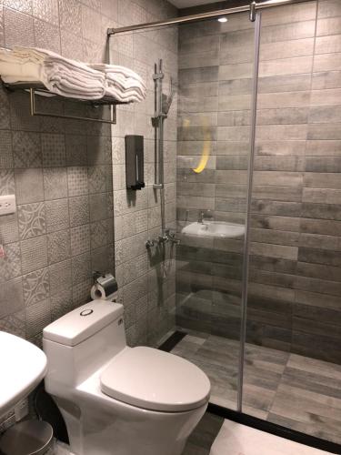 a bathroom with a shower and a toilet and a sink at Jiufen HappyLand B&B in Jiufen