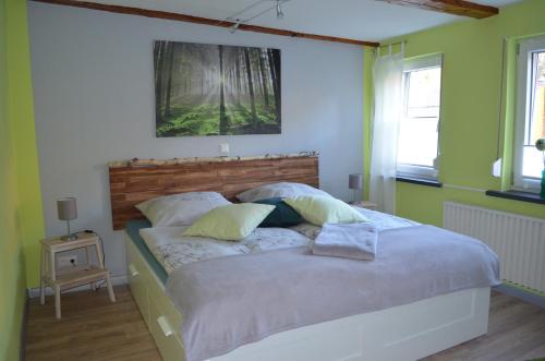 Cama grande en habitación con paredes verdes en Ferienwohnung Pusteblume en Wildemann
