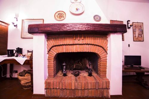 a brick fireplace in a living room with a clock on the wall at Il vecchio frantoio in Panicale