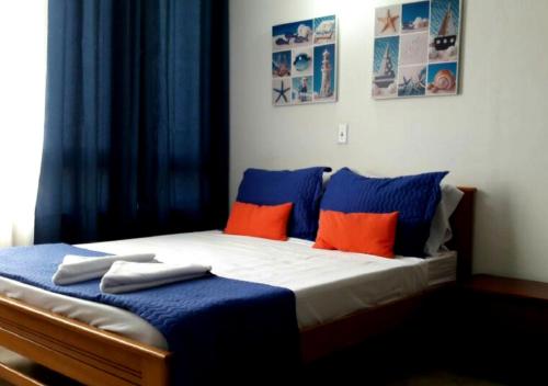 a bedroom with a bed with blue and orange pillows at Apartamento para parejas frente a la playa San Andres in San Andrés