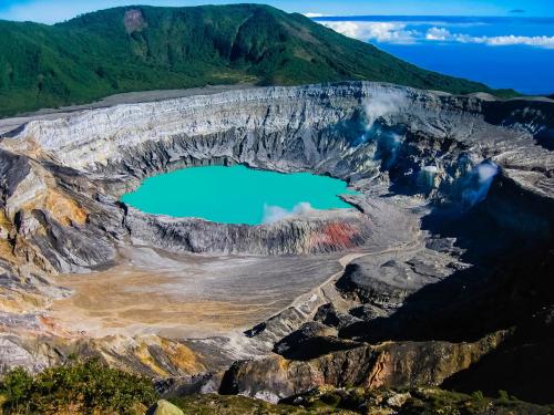 an aerial view of a mountain crater with a blue lake at Terida Airport B&B in Alajuela City