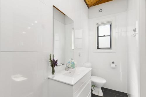 a white bathroom with a sink and a toilet at Blue Apple Lodge in Bilpin
