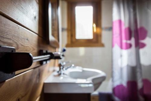 baño con lavabo blanco y ventana en Cabaña de campo en Agost