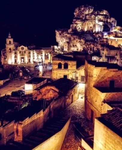 a view of a city at night with a castle at Caveoso Hotel in Matera