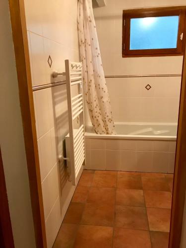 La salle de bains est pourvue d'une baignoire et d'un rideau de douche. dans l'établissement Chambres d'Hôtes La Téouleyre, à Saint-Julien-en-Born