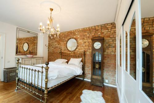 a bedroom with a brick wall with a bed and a chandelier at Old Town Kalēju Street in Rīga