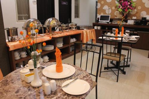 a room with a table with plates on it at Mel's Inn Manado in Manado