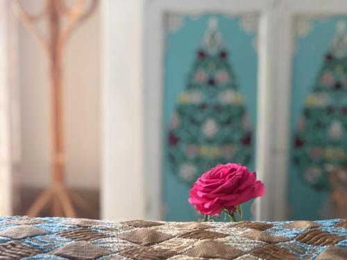 a pink flower sitting on a table with a christmas tree in the background at Riad Le Coq Berbère in Marrakech