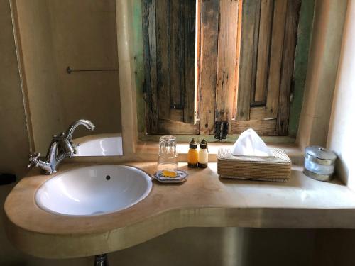 a bathroom counter with a sink and a window at Riad Le Coq Berbère in Marrakech