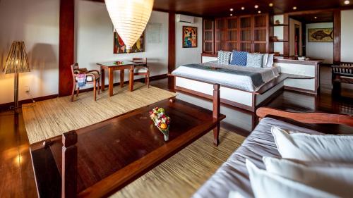a bedroom with two beds and a table with flowers on it at Hotel Sombra e Água Fresca in Pipa