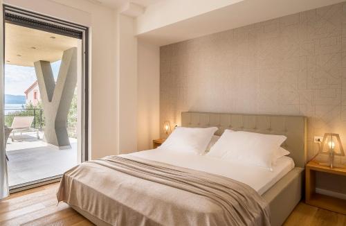 a bedroom with a large bed and a large window at Villa Olive Grove in Duće