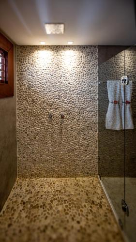 a shower with a glass door in a bathroom at Hotel Sombra e Água Fresca in Pipa