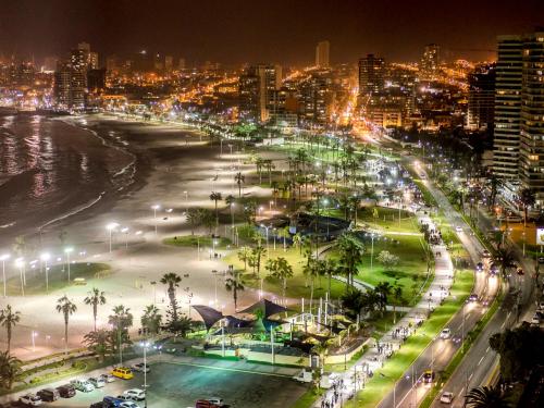 a city at night with a beach and street lights at Hotel Terrado Cavancha in Iquique
