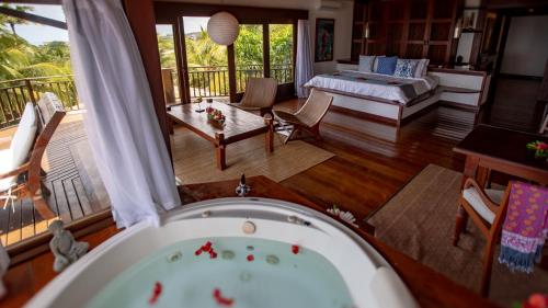 a bath tub in a living room with a porch at Hotel Sombra e Água Fresca in Pipa