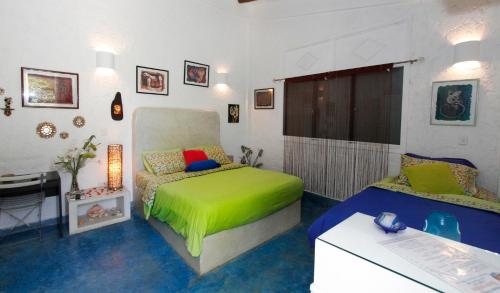 a bedroom with a green bed and a desk at StevieWonderLand Playa El Yaque in El Yaque