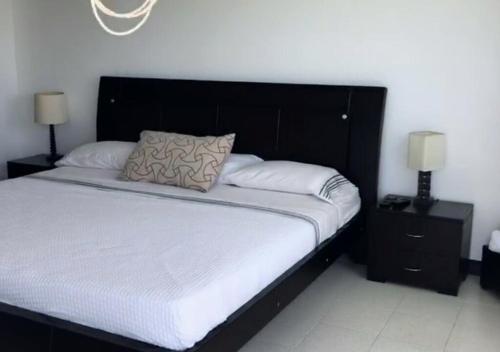 1 dormitorio con 1 cama grande y 2 mesitas de noche en Apartamento Familiar con Vista al Mar en San Andres, en San Andrés