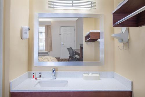 a bathroom with a sink and a mirror at Baymont by Wyndham Greenwood in Greenwood