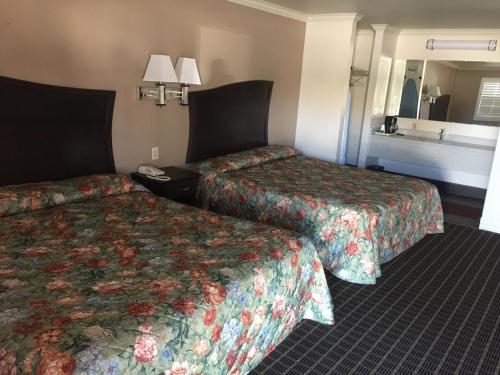 a hotel room with two beds and a mirror at Portal Motel in Lone Pine