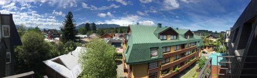 a building with a green roof in a city at Centrico departamento en Pucon in Pucón