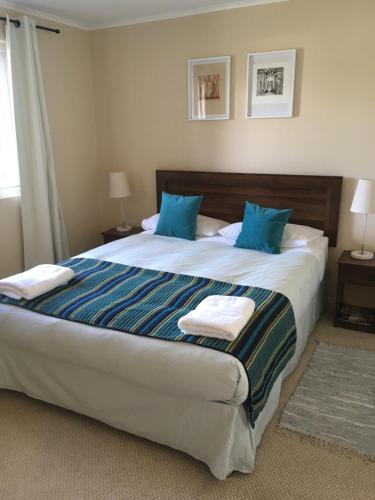 1 dormitorio con 1 cama grande con almohadas azules en Centrico departamento en Pucon, en Pucón