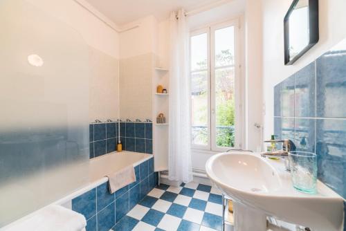 a blue and white bathroom with a tub and a sink at Newcenter Duplex in Auxerre