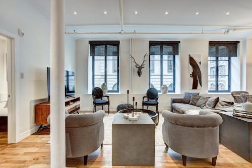 a living room with a couch and chairs at Saint Sulpice Lofts by Bakan - Old Montreal in Montréal