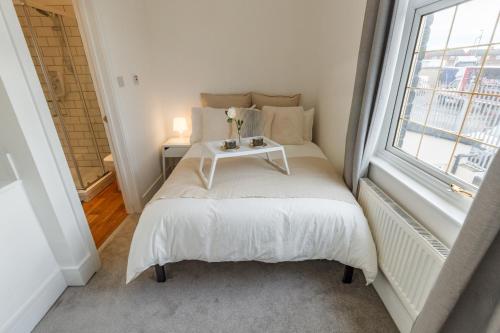 een kleine slaapkamer met een bed en een raam bij Sapphire Home Stay in Liverpool