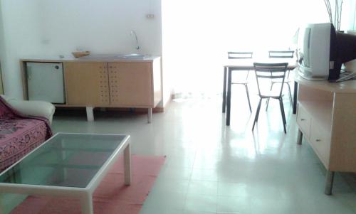 a living room with a couch and a table at M In Korat Service Apartment in Nakhon Ratchasima