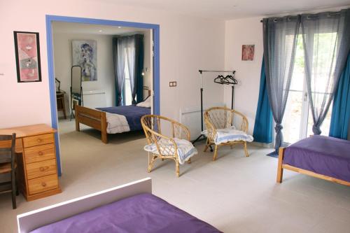een slaapkamer met 2 bedden en stoelen en een spiegel bij Chambres d'hôtes de la Fontaine in Beauchery