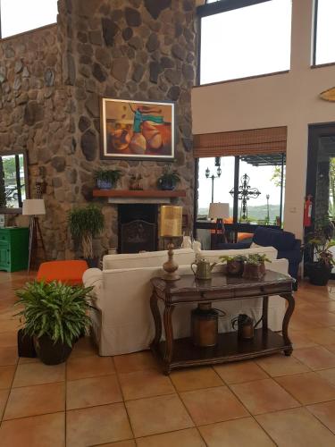a living room with a table and a stone wall at Hacienda Los Molinos Boutique Hotel & Villas in Boquete
