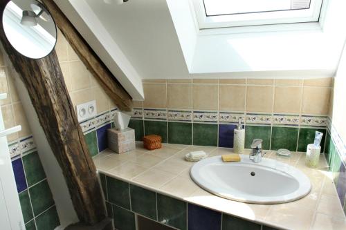 La salle de bains est pourvue d'un lavabo et d'une lucarne. dans l'établissement Chambres d'hôtes de la Fontaine, à Beauchery