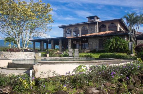 a house with a garden in front of it at Hacienda Los Molinos Boutique Hotel & Villas in Boquete