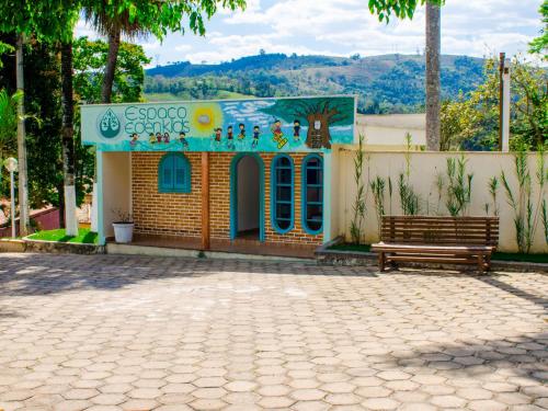 a small building with a bench in a park at Villa do Éden in Lindóia