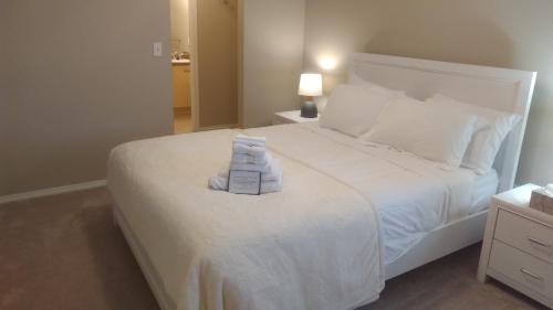 a bedroom with a white bed with towels on it at Quiet 2 Bed 2 Bath close to Westview Hospital in Stony Plain
