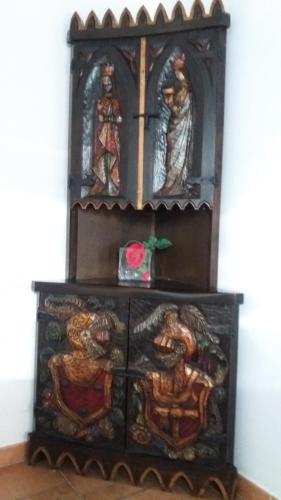 a wooden cabinet with three statues on it at Lagar II con Jacuzzi in Curiel de Duero