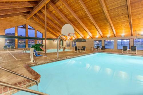 a large swimming pool in a building with a wooden ceiling at AmericInn by Wyndham Wisconsin Dells in Wisconsin Dells