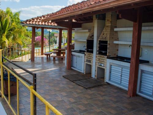 a patio with an outdoor kitchen on a deck at Villa do Éden in Lindóia