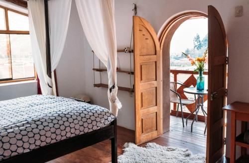 a bedroom with a bed and an open door at La Chakana Pisac in Pisac
