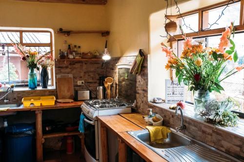 cocina con fregadero, fogones y ventanas en La Chakana Pisac, en Písac