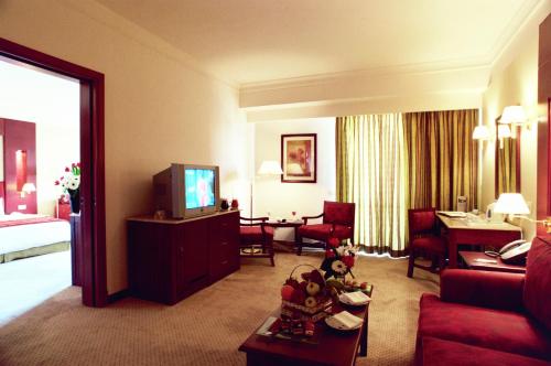 a hotel room with a living room with a television at Safir Hotel Cairo in Cairo