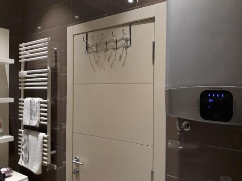 スボティツァにあるApartman Prestige Centerのハンガーが付いた白いドアのあるバスルーム