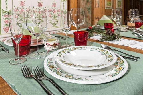 a table with a plate and wine glasses on it at Albergo Chalet Lago Antorno in Misurina
