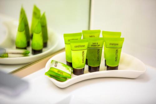 a group of green toothbrushes on a plate on a counter at Nightcap at Shoppingtown Hotel in Doncaster