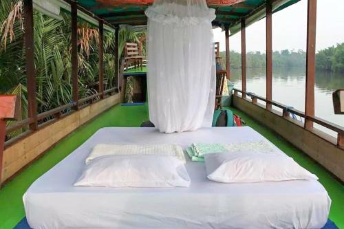 Postel nebo postele na pokoji v ubytování Orang Utan Houseboat 2