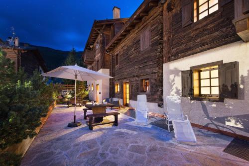 a patio with an umbrella and a table and chairs at Chalet Matteo in Livigno