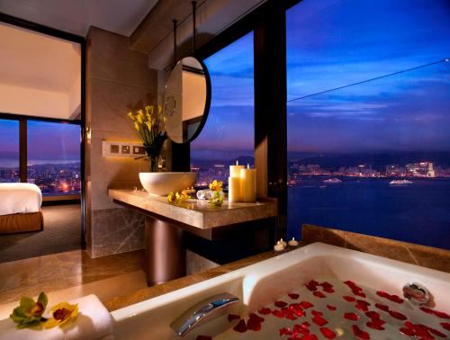 a bathroom with a tub and a window with a view at Harbour Grand Hong Kong in Hong Kong