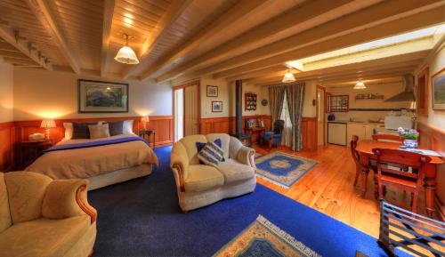 a bedroom with a bed and two chairs and a desk at Old WesleyDale Heritage Accommodation in Mole Creek