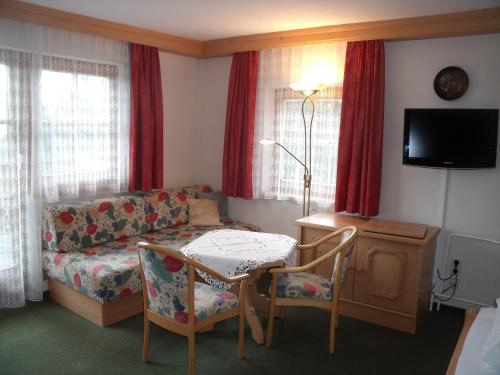 a living room with a couch and a table with chairs at Gasthof Edelbrunn in Ramsau am Dachstein