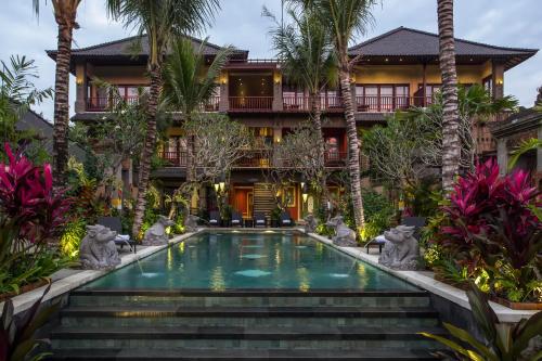 einen Blick nach außen auf ein Resort mit einem Pool und Palmen in der Unterkunft Dwaraka The Royal Villas in Ubud